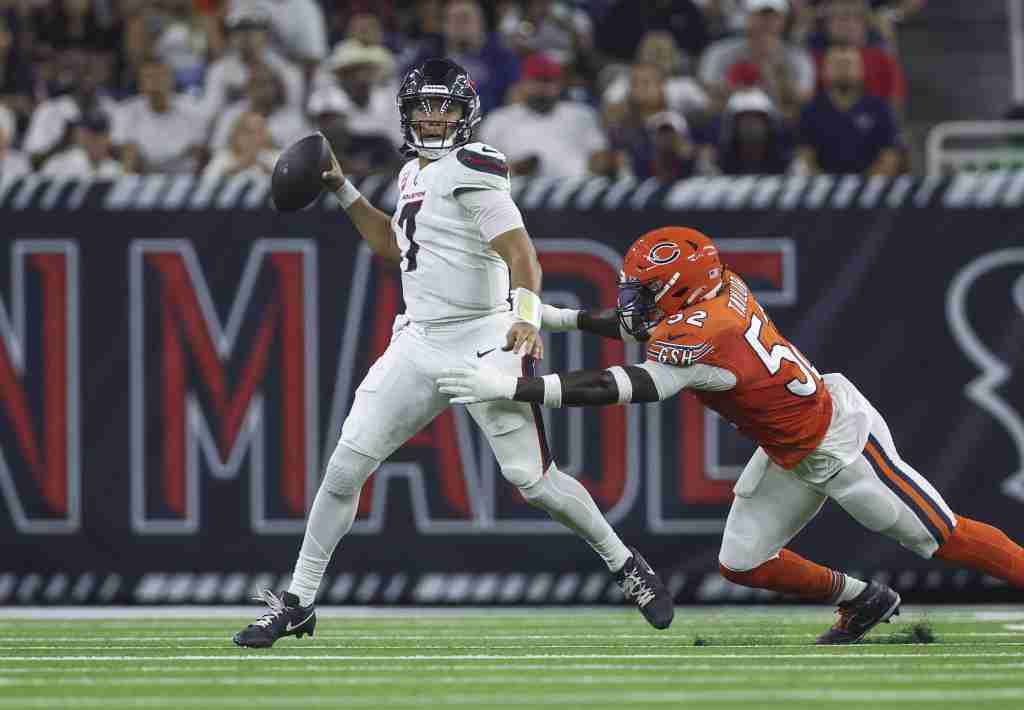 Sep 15, 2024; Houston, Texas, USA; Houston Texans quarterback C.J. Stroud (7) scrambles with the ball as Chicago Bears defensive end Darrell Taylor (52) defends during the second quarter at NRG Stadium. Mandatory Credit: Troy Taormina-Imagn Images
