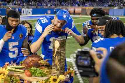 Nov 28, 2024; Detroit, Michigan, USA; Detroit Lions quarterback Jared Goff (16) takes a bite of the John Madden MVP Turkey with teammates after the annual Thanksgiving Day game defeating the Chicago Bears at Ford Field. Mandatory Credit: David Reginek-Imagn Images